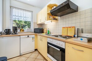 A compact kitchen with a dishwasher, microwave, stove, and oven.