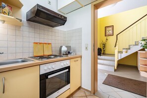 A kitchen with a stove, oven, and a coffee maker.