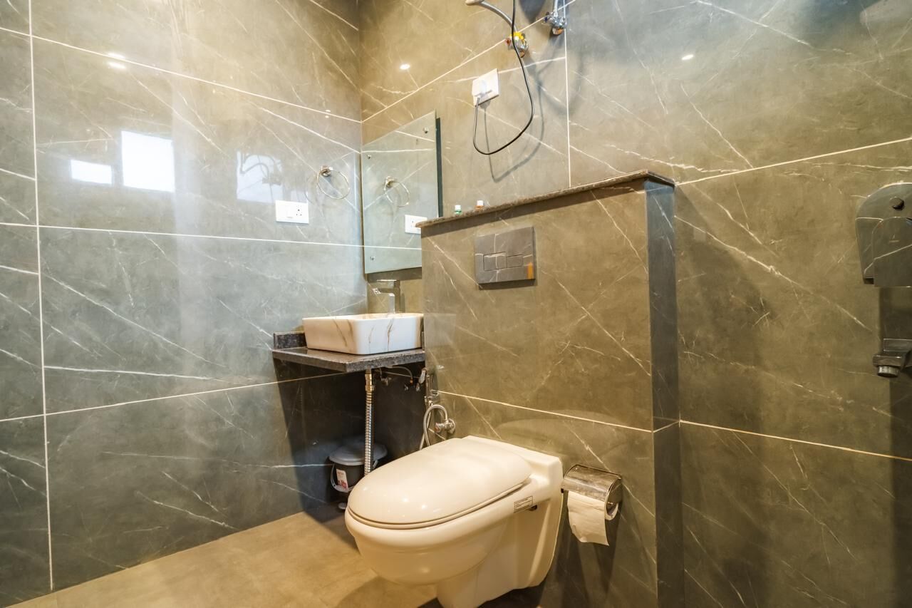 Ein modernes Badezimmer mit Toilette, Waschbecken und Duschbereich.