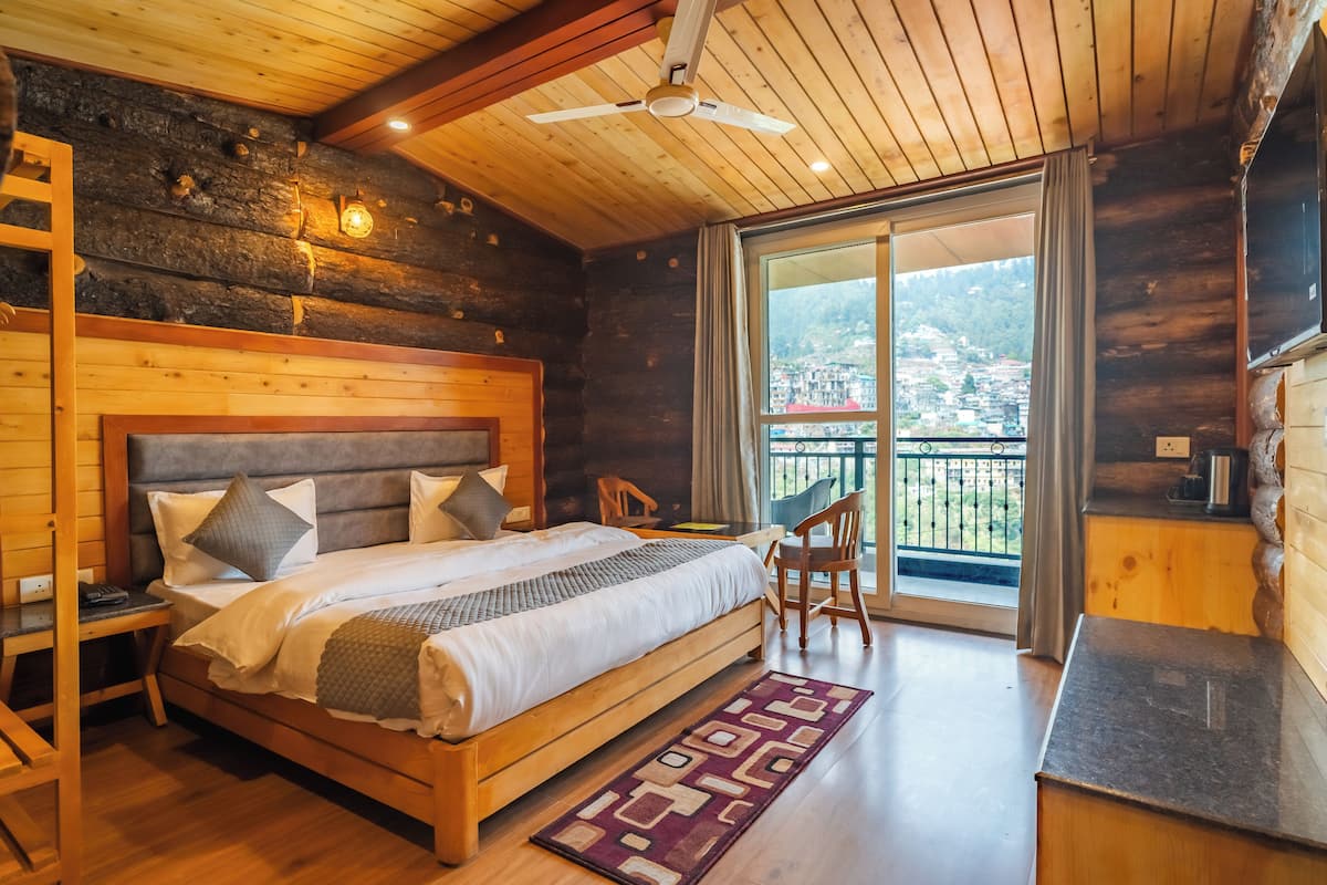 Un dormitorio de cabaña de madera con cama, escritorio y silla.