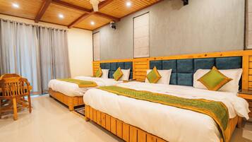 A hotel room with two wooden beds, a wooden chair, and a ceiling fan.