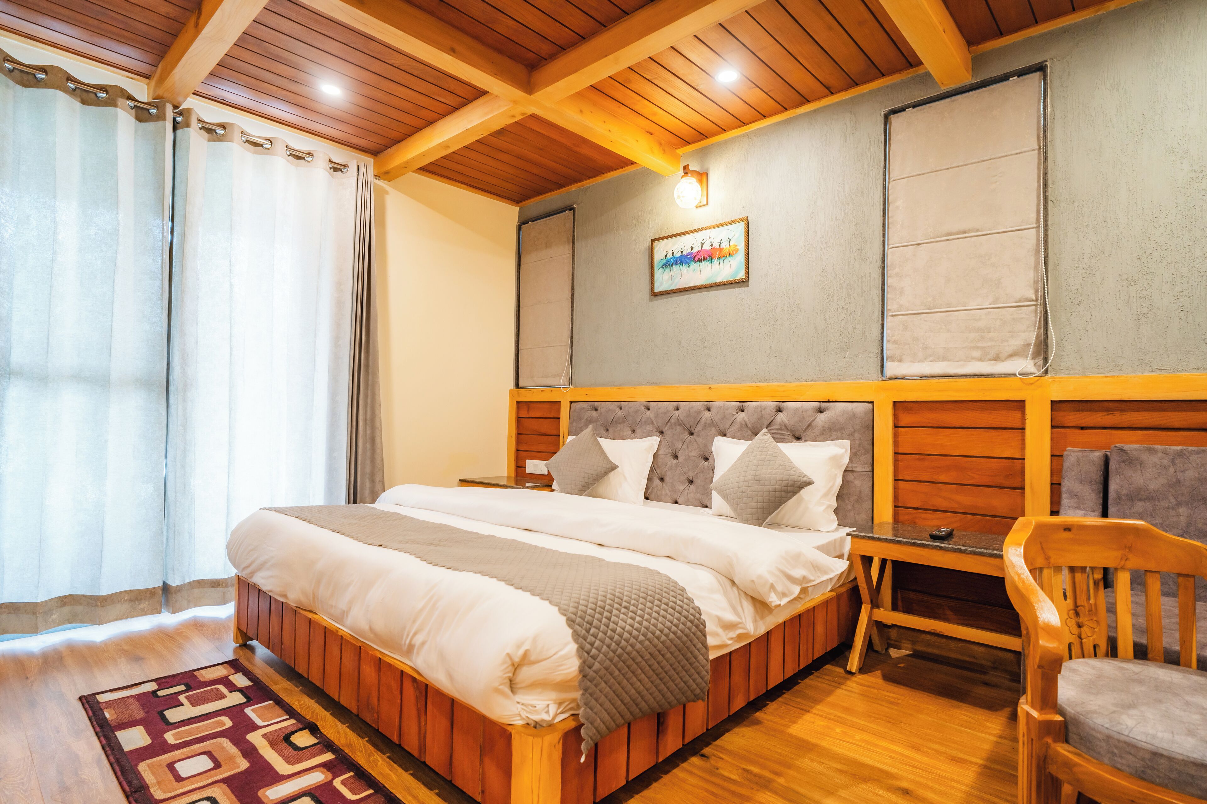 Une chambre à coucher bien rangée, avec un lit en bois, une table de chevet, une chaise et un luminaire fixé au mur.