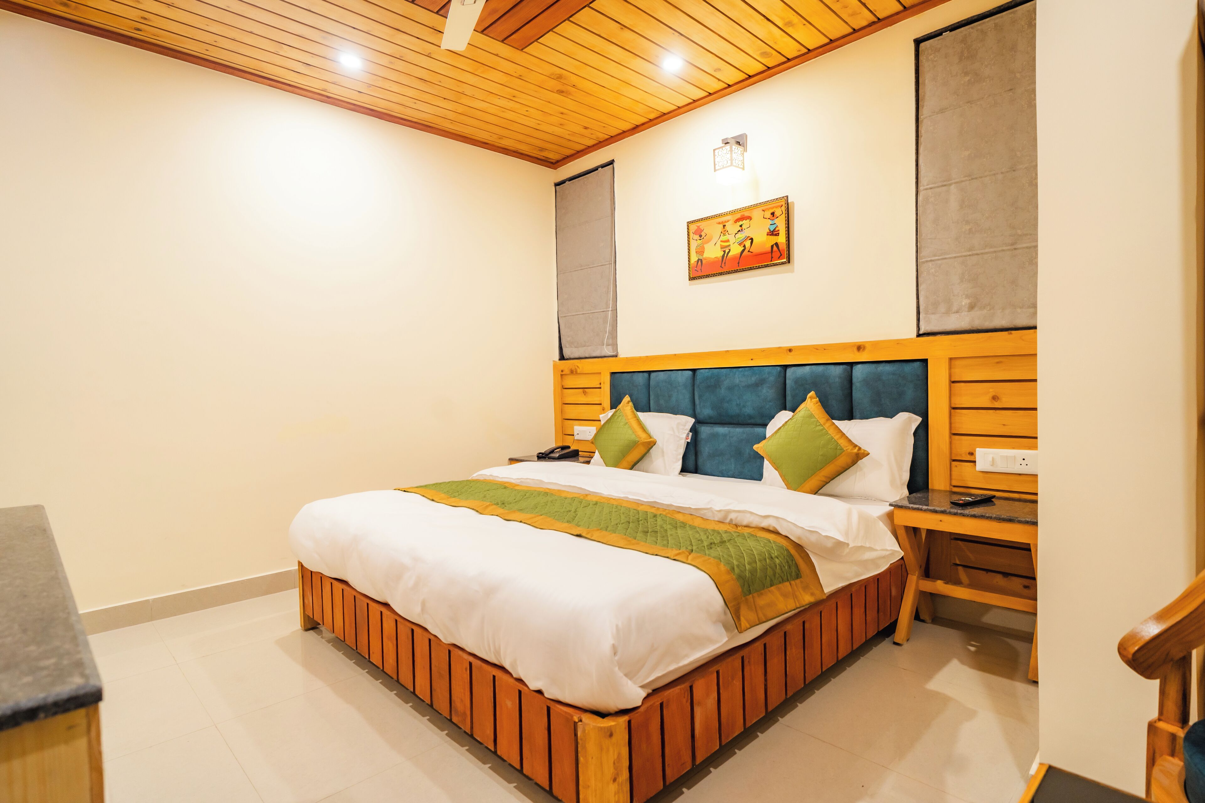 A bedroom with a wooden bed, a nightstand, a chair, and a painting on the wall.