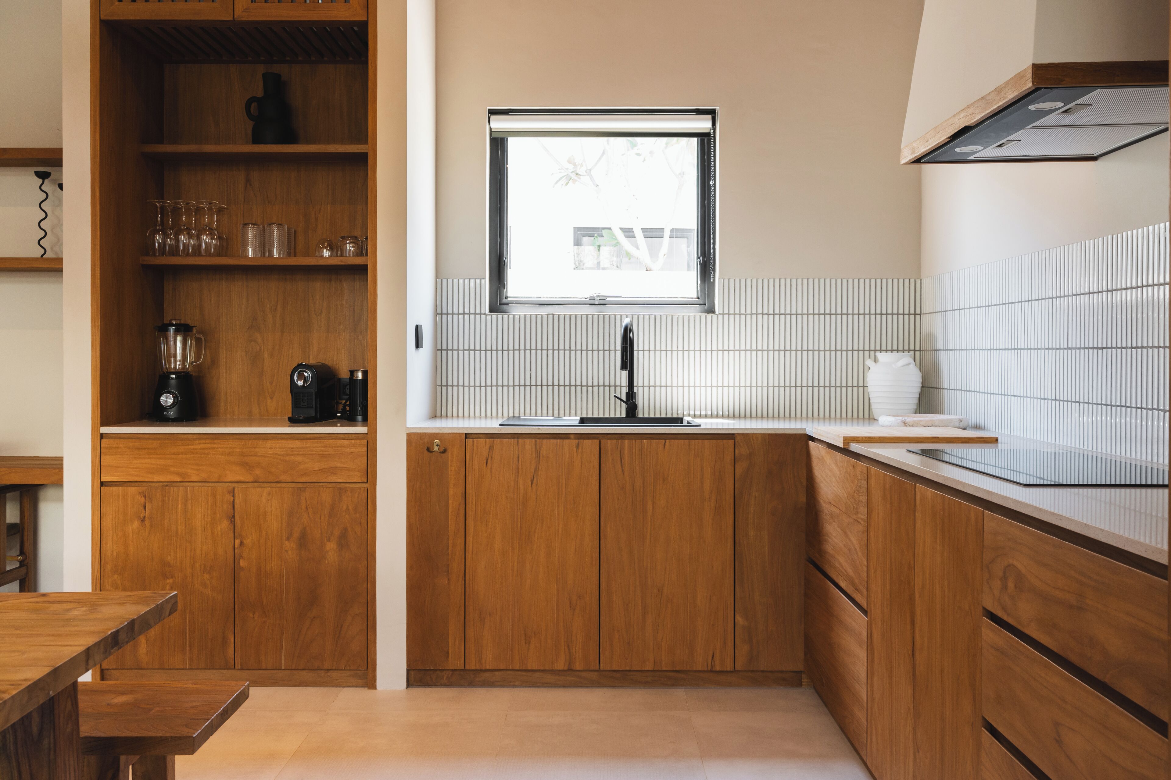 A modern kitchen with wooden cabinets, a built-in window, and a tiled backsplash.