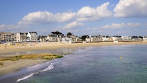 Une plage côtière avec des bâtiments en arrière-plan.