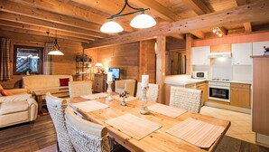 Interior acogedor de una cabaña de madera con comedor, cocina y sala de estar.