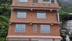 A multi-story building with a flat roof and a balcony on the upper floor. - Hotel East Inn (Gangtok)