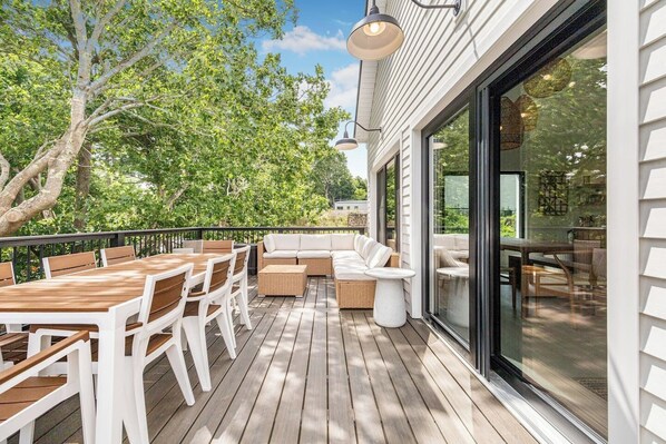 A deck with outdoor furniture, a sofa, and a dining table.
