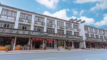 A multi-story building with storefronts on the ground floor, featuring a variety of shops and restaurants.