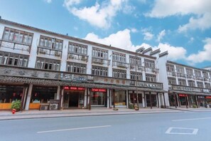 A multi-story building with storefronts on the ground floor, featuring a variety of shops and restaurants. - Wuzhen Chaifeng Homestay (Tongxiang)