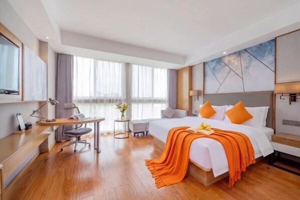 A hotel room with a large bed, a desk, a chair, and a small table. - Guangzhou Termeisheng Hotel (Guangzhou)