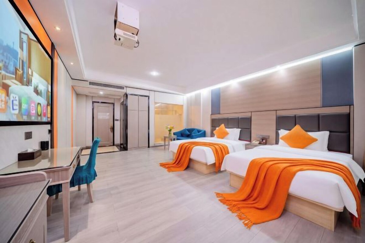 Habitación de hotel moderna con dos camas, un escritorio y una zona de estar.