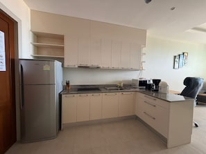 Una cocina moderna con un refrigerador Siemens, un microondas, una cafetera y un lavamanos.