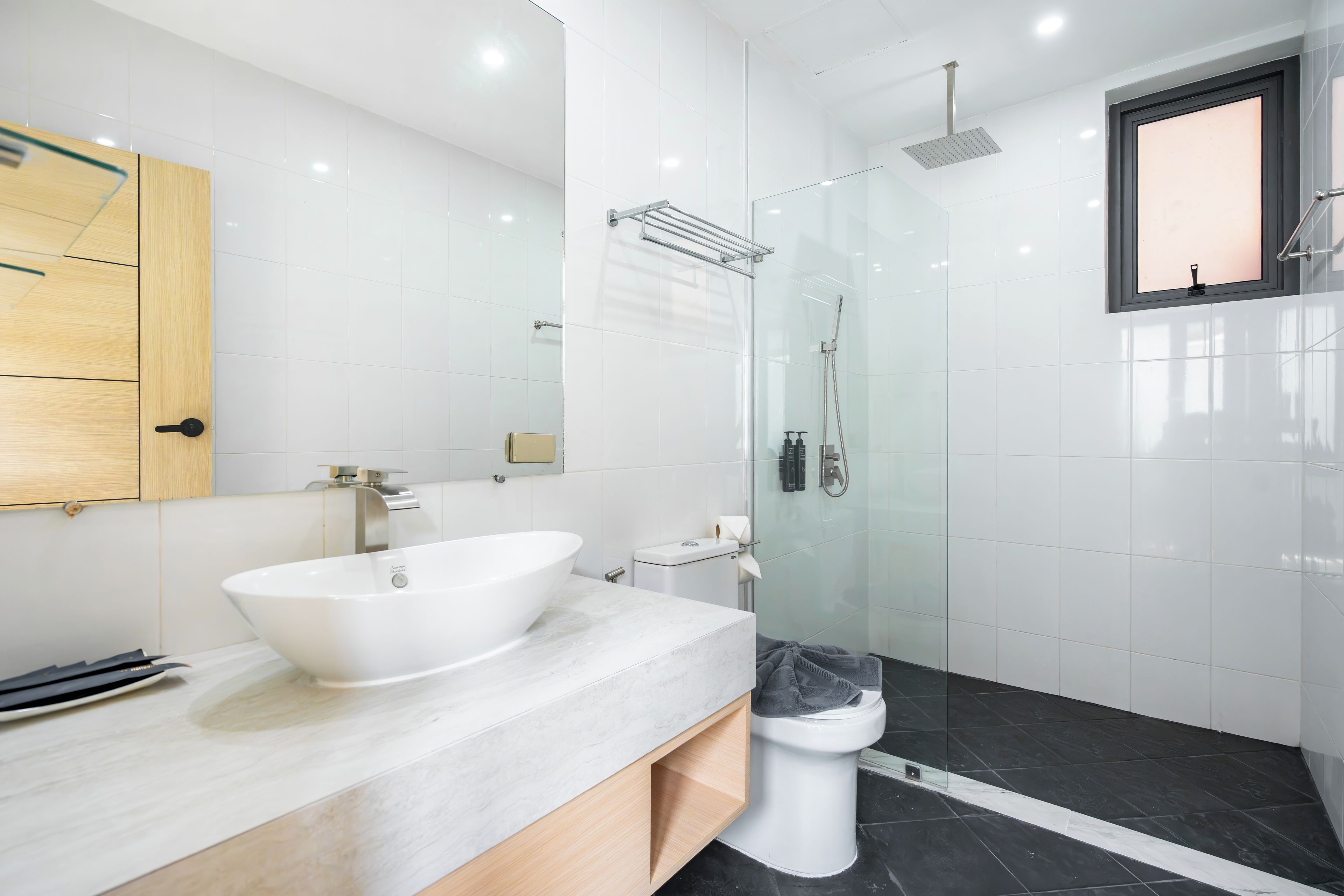 Een moderne badkamer met een vrijstaand ligbad, een toilet en een douchecabine met glazen wanden.