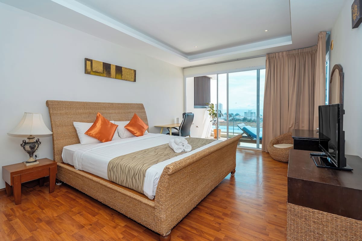 Habitación de hotel con una cama grande, televisión, escritorio y vistas a la ciudad.