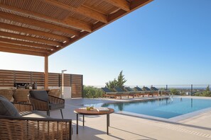 A rooftop pool area with lounge chairs, a table with a book and fruit, and a pergola overhead. - Olvios Villa II, with 35m² Pool & SeaViews (895J+HF3 Chersonisos, Greece)