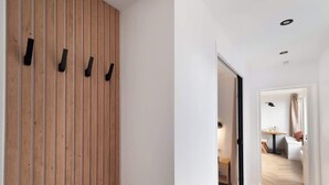 A hallway with wooden paneling and a modern kitchen visible through an open door. - Appartement Le Marais - 1 Bedroom (Paris)