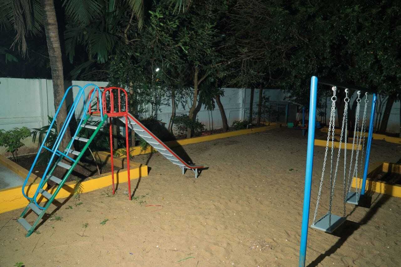A playground with a slide, swing set, and climbing structure.