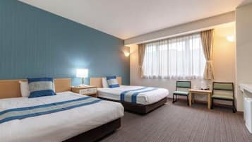 Habitación de hotel con dos camas, un escritorio, una silla, una mesita de noche y una ventana con cortinas.