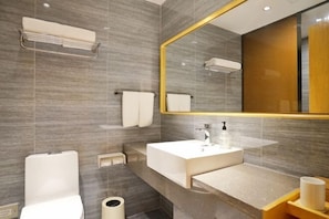 A modern bathroom with a large mirror, a toilet, a sink, and a towel rack. - New Xana Hotel (Xi'an)