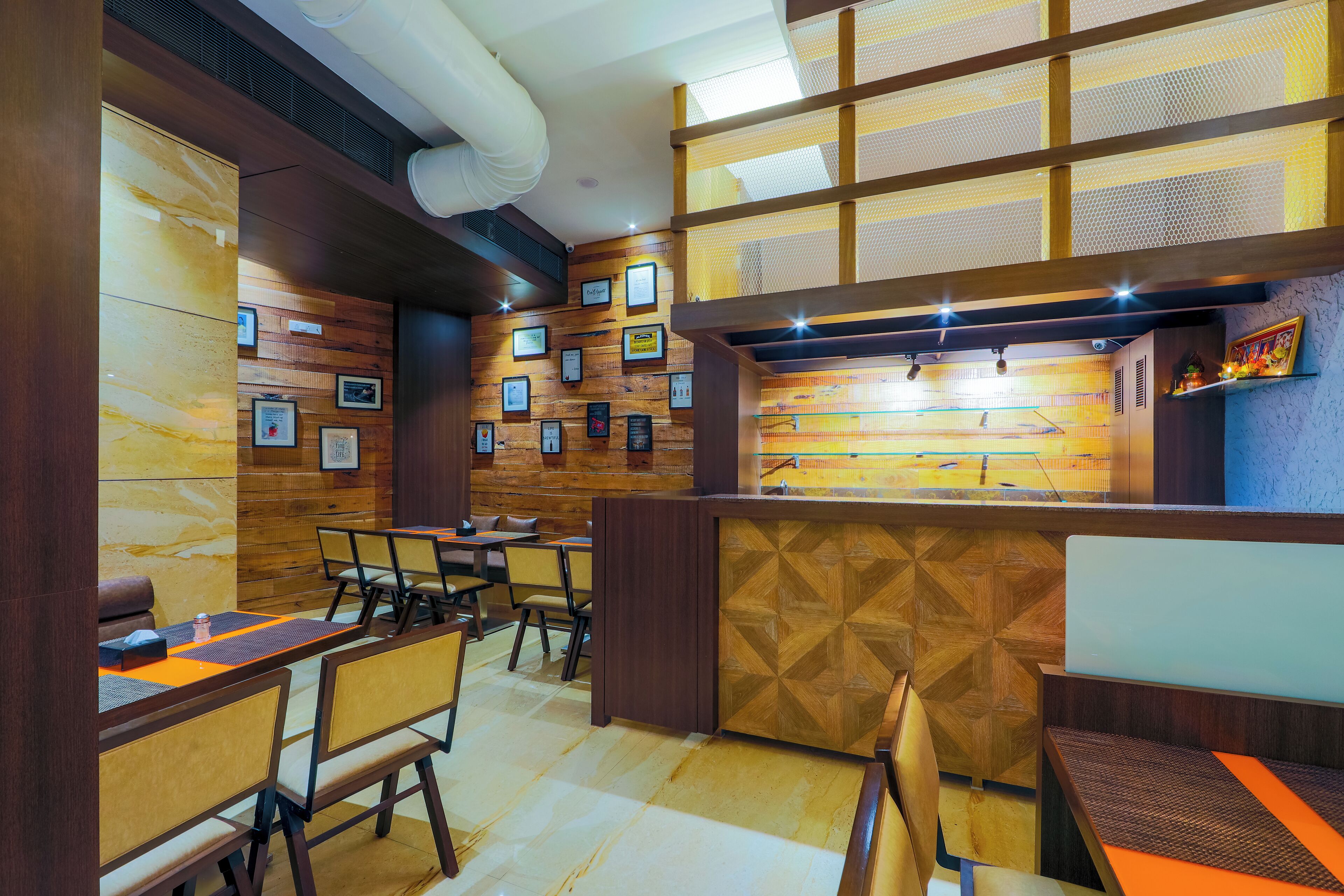 Un restaurant aux murs en bois, orné de tableaux encadrés, et doté d’un comptoir offrant une vue sur la rue.