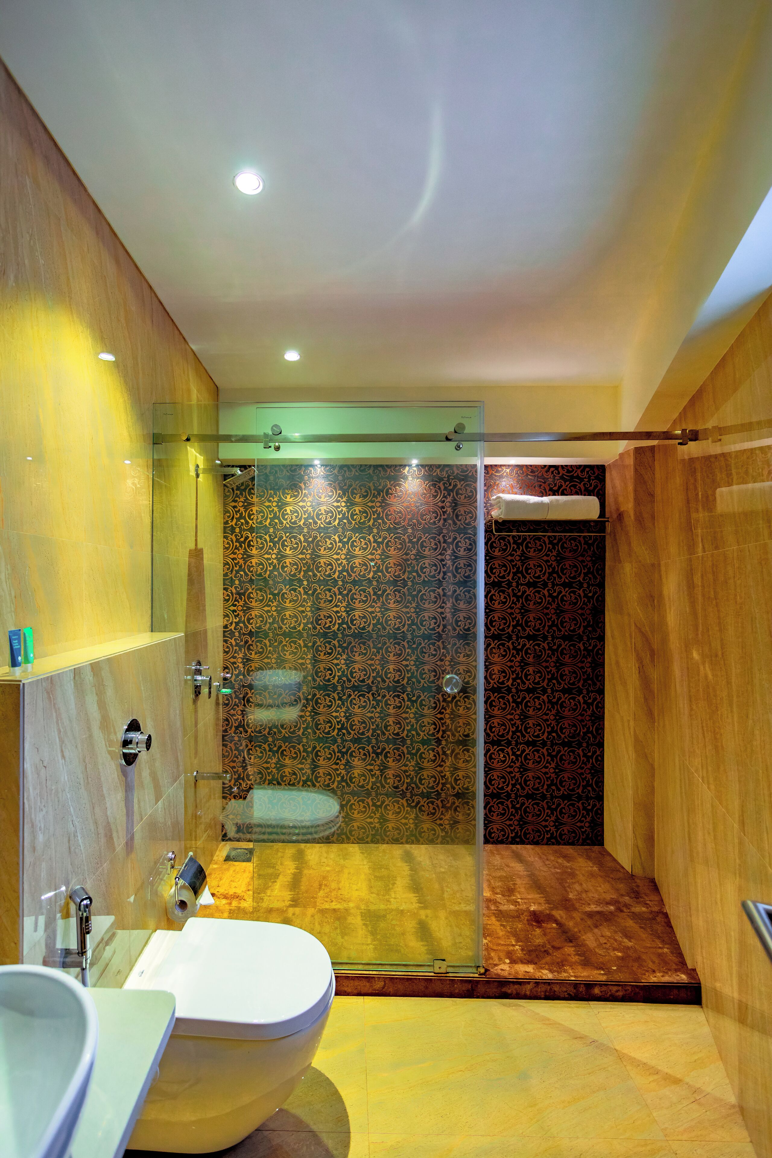 A modern bathroom with a glass-enclosed shower, a large sink, and a toilet.