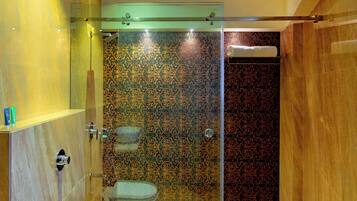 A modern bathroom with a glass-enclosed shower, a large sink, and a toilet.