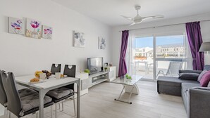 A modern living room with a dining area, a TV, and artwork on the walls. - Parque Don Jose Poolside Retreat by Interhome (Costa del Silencio)