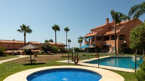 A swimming pool surrounded by a fence, with a building in the background. - Pia's Sea Dream by Interhome (Estepona)