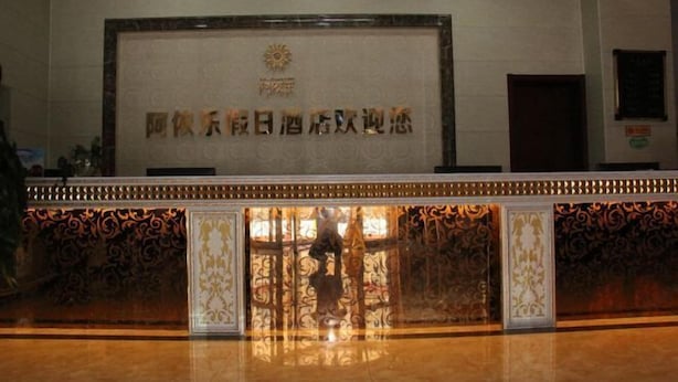 A reception area with a marble counter and ornate metalwork. - Ayile Holiday Hotel (Yining City)