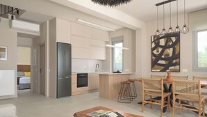 Een moderne keuken met een inbouwkoelkast, houten kastjes en een groot raam. Er staan rieten stoelen bij een eettafel.