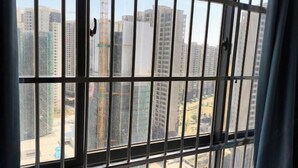 Vista a través de una reja que muestra edificios altos al fondo, algunos en construcción.