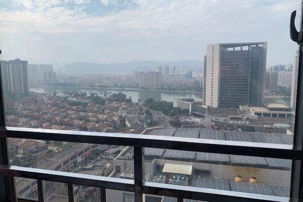 A cityscape view from a high-rise building with a river and various buildings in the background.