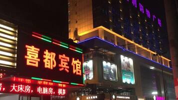 A hotel with illuminated signage and a modern facade.