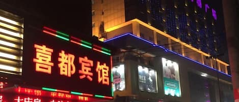 Un hotel con letreros iluminados y fachada moderna.