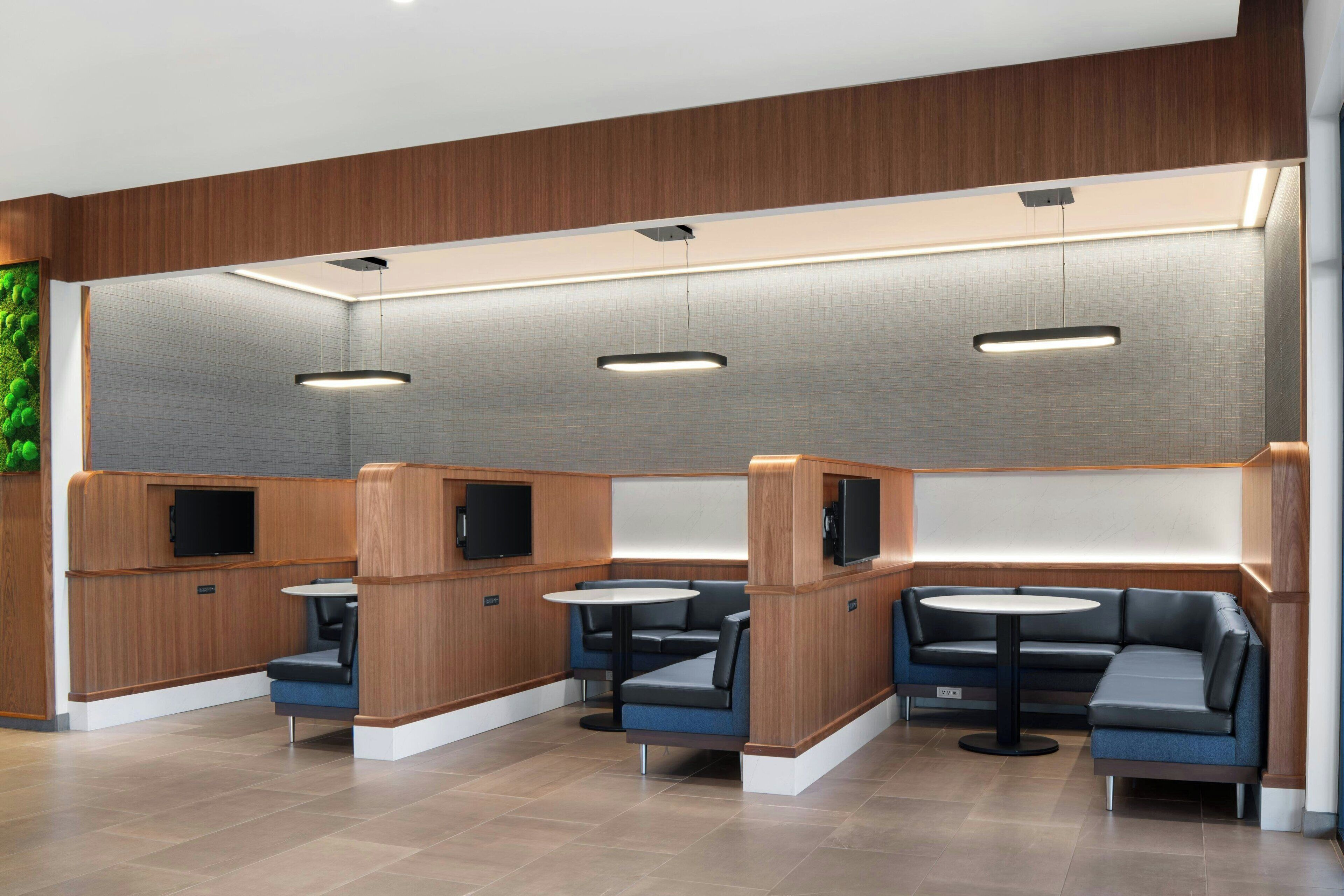A modern interior with seating areas, tables, and recessed lighting.