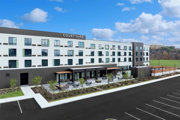 A Courtyard by Marriott hotel with a modern design, outdoor seating area, and a parking lot. - Courtyard by Marriott Kodak Sevierville (Kodak)
