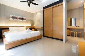 Un dormitorio moderno con una cama grande, un cuadro con un paisaje urbano en la pared, un armario de madera y una pequeña zona de kitchenette.