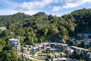 Una zona residencial moderna con edificios de varios pisos rodeada de un bosque frondoso.