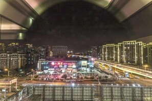 A nighttime cityscape with a prominent building featuring illuminated signage. - Fujun Meicheng Hotel (Suzhou)