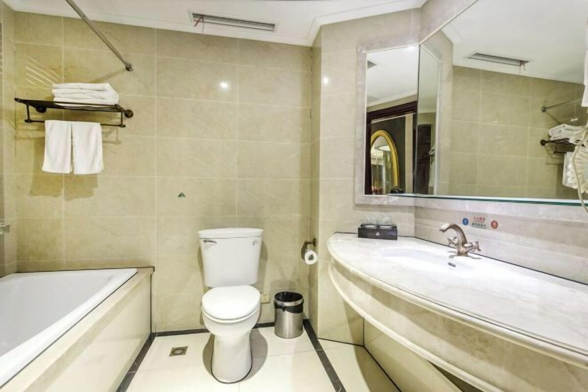 A modern bathroom with a toilet, sink, and bathtub.