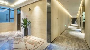 A hotel corridor with a marble floor, a potted plant, and a number '3F' sign. - Fujun Meicheng Hotel (Suzhou)