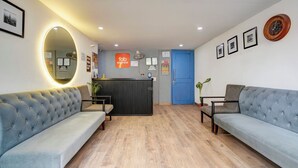 Een receptiezone met een modern ontwerp, met een receptiebalie, banken en een grote spiegel.