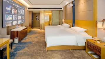 Une chambre d’hôtel avec un grand lit, un bureau, une télévision et une salle de bain visible à travers une porte ouverte.