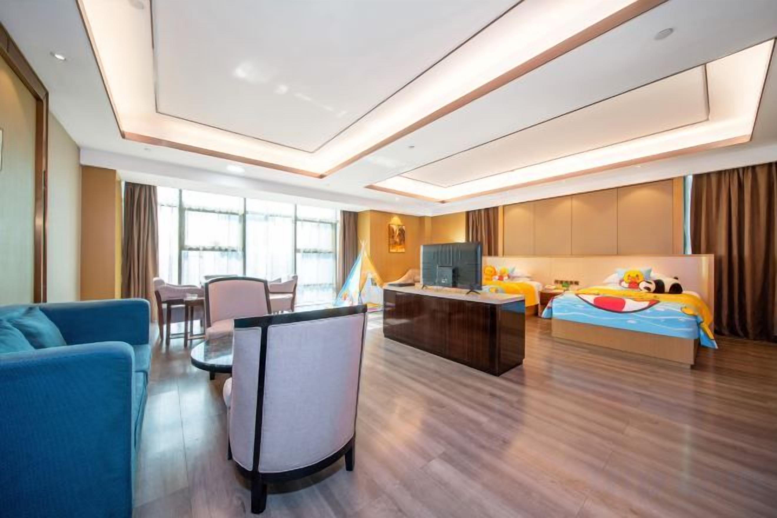 Una habitació d'hotel amb un llit, una taula de treball, una cadira i un sofà.