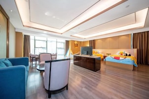 Una habitación de hotel con cama, escritorio, silla y sofá.