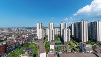 Zona residencial de gran altura con varios edificios de apartamentos, cielo despejado y una vista distante de una masa de agua.