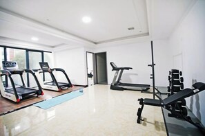 A gym with treadmills, a stationary bike, and weightlifting equipment. - Yujingyuan Hotel (Taoyuan)