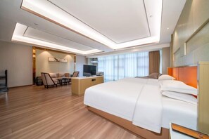 A modern hotel room with a large bed, a desk, and a television. - Yujingyuan Hotel (Taoyuan)
