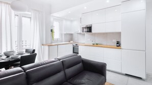 A modern kitchen with white cabinets, a wooden countertop, and a built-in oven.